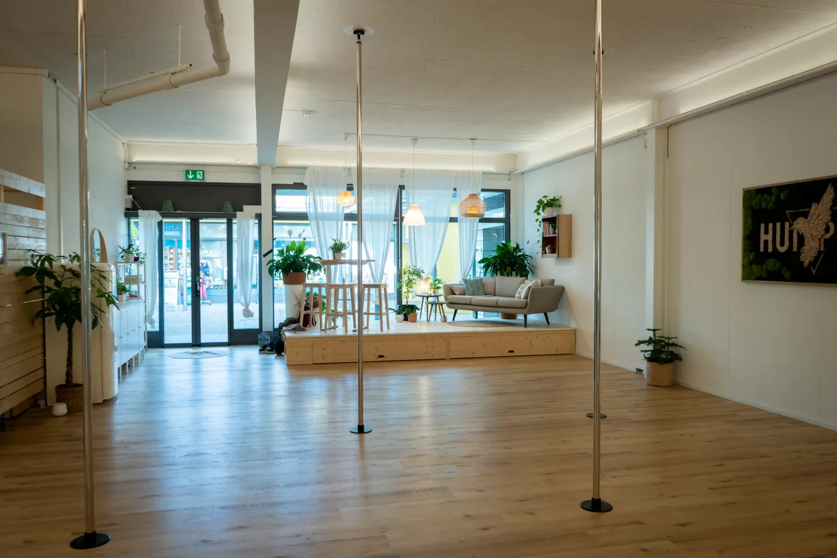 Poledance-Studio Humpty 7, mit Polestangen und Fensterfront und Sofa.